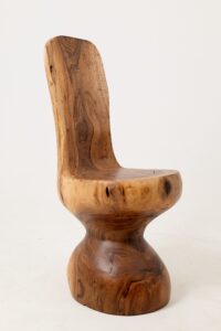 A tall curved paddle backrest and deep bowl seat flow into an hourglass pedestal base on this walnut chair, sweeping swirled grain throughout.